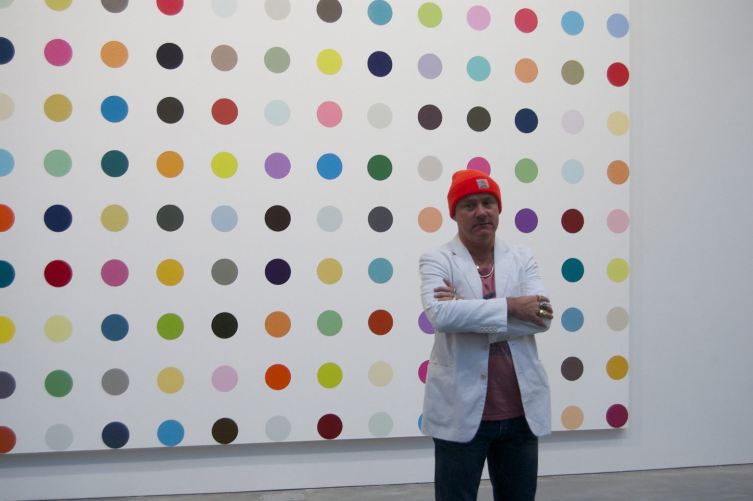 Daniel Hirst sitting by one of the most famous and expensive paintings and artwork he produced